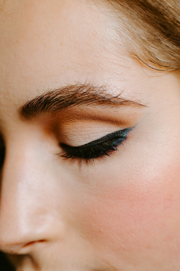 ahaufnahme eines menschlichen Gesichts mit braunem Augen-Make-up, schwarzem Lidschatten und getuschten Wimpern mit Mascara