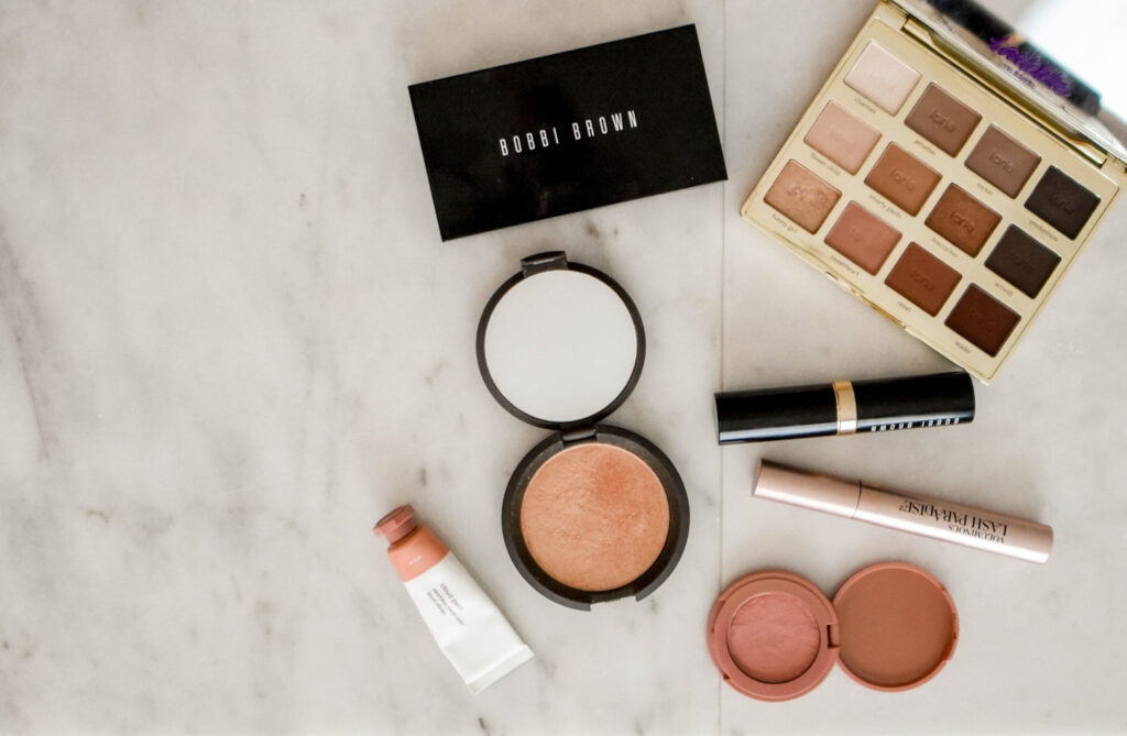 Make-up Lidschatten Palette, Mascara, Bronzer auf grauem Hintergrund